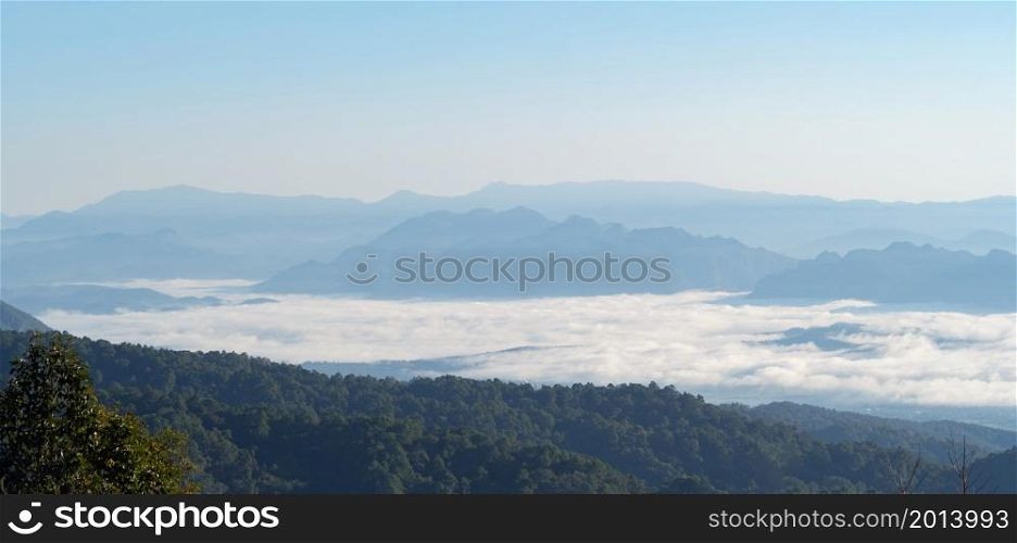 Aerial view of sunrise above fluffy sea fog misty clouds with mountain hill peak, Khao Kho, Phetchabun, Thailand with sunlight. Nature landscape background with blue sky.