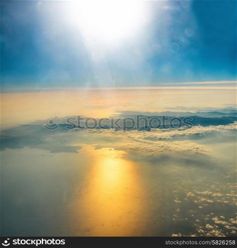 Aerial view of sunset on the sky with sunrays. Fluffy clouds background