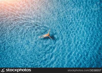 Aerial view of swimming woman in mediterranean sea. Aerial view of swimming woman in mediterranean sea in Oludeniz, Turkey. Summer seascape with girl, clear azure water, waves at sunset. Transparent water.Top view from flying drone. Travel