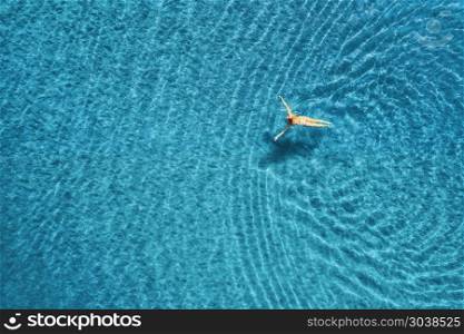 Aerial view of swimming woman in the sea at sunset in Maldives. Aerial seascape with young girl, clear blue water, waves in summer. Transparent water. Top view. Resort on seashore. Holiday. Aerial view of swimming woman in mediterranean sea. Aerial view of swimming woman in the sea at sunset in Maldives