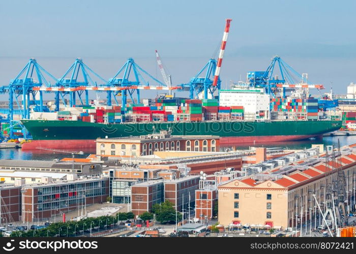 Aerial view of the city and sea cargo port. Large container ship is loaded into the container terminal of Genoa.. Genoa. Cargo port.