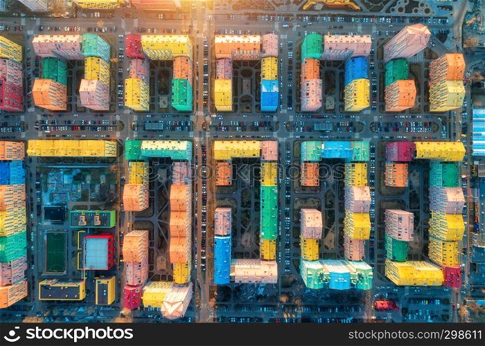Aerial view of the colorful buildings in european city at sunset. Cityscape with multicolored houses, cars on the street in Kiev, Ukraine. Top view. Urban landscape. Aerial photo of a downtown