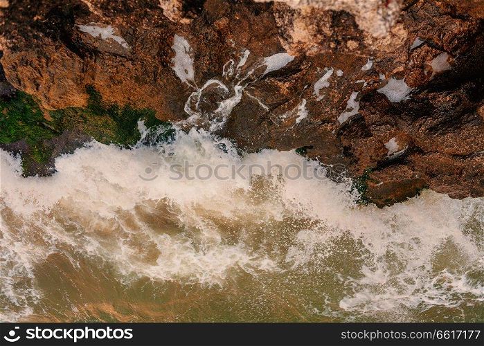 Aerial view of the disturbed sea and the rock. Aerial view of the tropical ocean and the rocky coast, toned in vintage color. Aerial view of the disturbed sea and the rock. Aerial view of the tropical ocean and the rocky coast