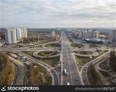 Aerial view of the drone on the Odessa square with highway in the form of a quatrefoil with passing cars and a modern city against a cloudy sky autumn day. Kiev, Ukraine. Modern city with of Odessa square and road in the form of a quatrefoil on a background of a cloudy sky . Aerial view from the drone. Kiev, Ukraine