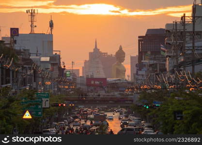 Aerial view of the Giant Golden Buddha in Wat Paknam Phasi Charoen Temple with cars on traffic street road in Phasi Charoen district, Bangkok. Urban town, Thailand. Downtown City.