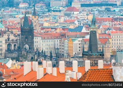 Aerial view of the historic center of Prague with towers, spiers and red-tiled roofs.