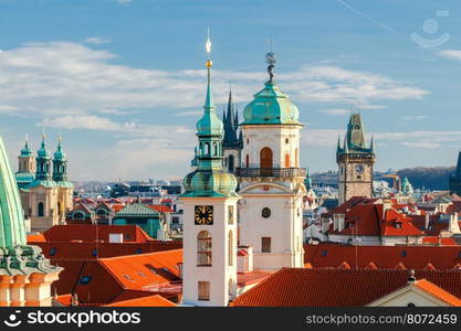 Aerial view of the historic center of Prague with towers, spiers and red-tiled roofs.