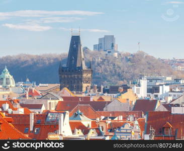 Aerial view of the historic center of Prague with towers, spiers and red-tiled roofs.