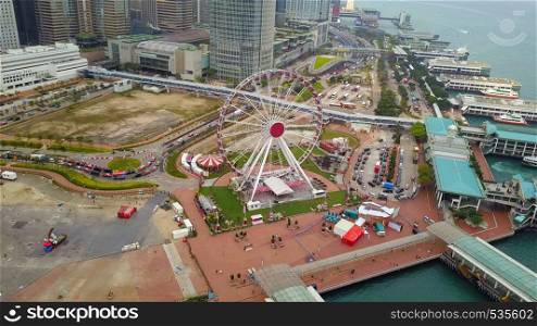 Aerial view of the Hong Kong Observation Wheel and amusement park for kids in holiday and travel concept. Hong Kong City. Downtown and Victoria Harbour.
