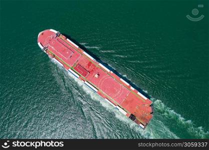 Aerial view of the huge ro-ro ship loading new cars. Automotive container carriers sailing on the sea services. Transportation business for prefabricated cars by sea freight