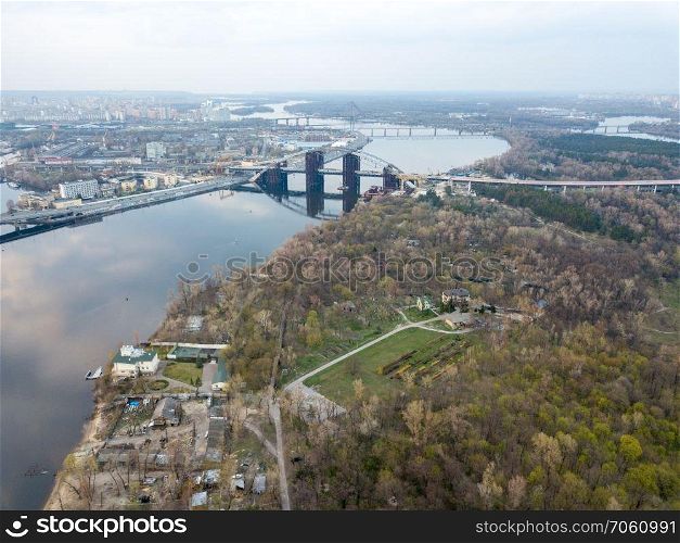 Aerial view of the Kiev  Kyiv  city, Ukraine. Dnieper river with Dniprovsky park and bridges. Obolon district in the background. Drone photo. Dnieper river with Dniprovsky park and bridges in Kiev, Ukraine