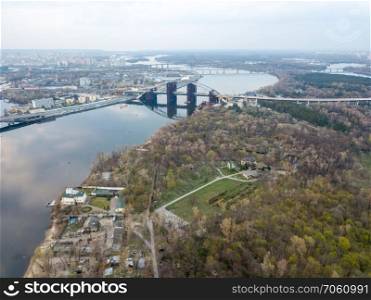 Aerial view of the Kiev  Kyiv  city, Ukraine. Dnieper river with Dniprovsky park and bridges. Obolon district in the background. Drone photo. Dnieper river with Dniprovsky park and bridges in Kiev, Ukraine