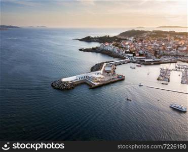 Aerial view of the lighthouse and harbour of Portonovo, a small village in the coast of Galicia, Spain, with the Cies and Ons islands in the background.