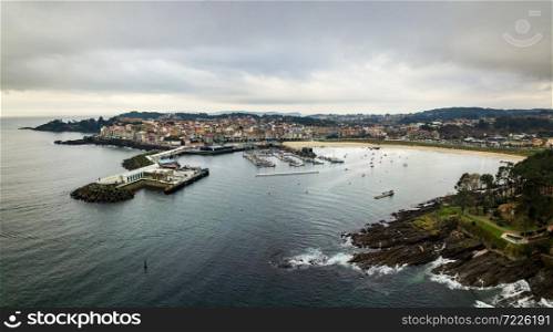 Aerial view of the lighthouse and harbour of Portonovo, a small village in the coast of Galicia, Spain, with the Cies and Ons islands in the background.