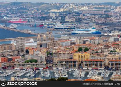 Aerial view of the port with ships and yachts near moorings on a sunny day. Marseilles. France.. Marseilles. Aerial view of the old and new port with ships and yachts.