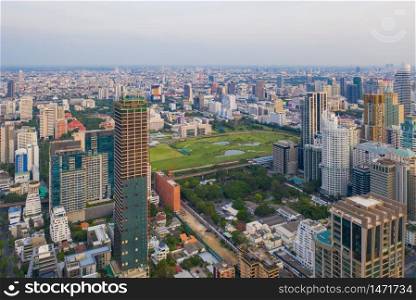 Aerial view of The Royal Bangkok Sports Club in Ratchadamri district, Bangkok Downtown Skyline. Thailand. Financial district in smart urban city in Asia. Skyscraper and high-rise buildings at sunset.