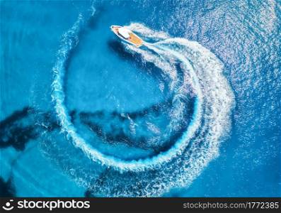 Aerial view of the speed boat in clear blue water at sunny day in summer. Top view from drone of fast floating yacht in mediterranean sea. Travel in Oludeniz, Turkey. Tropical landscape with motorboat