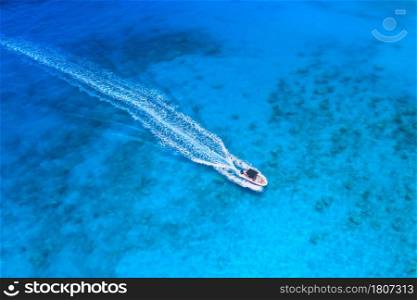 Aerial view of the speed boat in clear blue water at sunset in summer. Top view from drone of fast floating yacht in mediterranean sea. Travel in Oludeniz, Turkey. Tropical landscape with motorboat