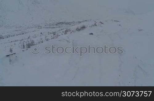Aerial view of the stray car on snowy off road