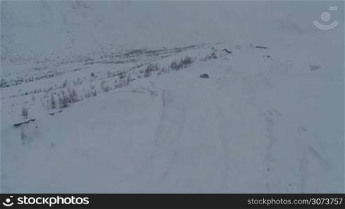 Aerial view of the stray car on snowy off road