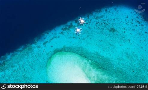 Aerial view of the Sumilon island, sandy beach with tourists swimming in beautiful clear sea water of the Sumilon island beach, Oslob, Cebu, Philippines.