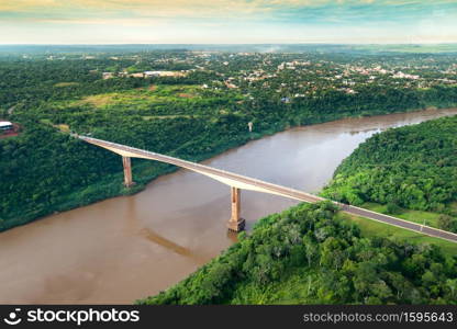 Aerial view of The Tancredo Neves Bridge, better known as Fraternity Bridge connecting Brazil and Argentina through the border over the Iguassu River, with the Argentinian city of Puerto Iguazu in the back.