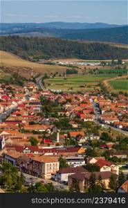 Aerial view of the town center with hills, buildings, streets, vegetation and surroundings in Rupea, Romania, 2021