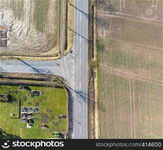 Aerial view of the turn off to the left of a country road in Germany. Abstract impression due to vertical angle of view. Made with drone