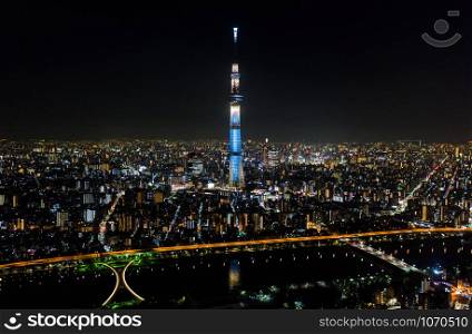 Aerial view of Tokyo Skytree, Sumida river, and Japanese landscape in Tokyo city at night. Japan tourism, cityscape landmark, Asia travel destination, or modern building architecture concept