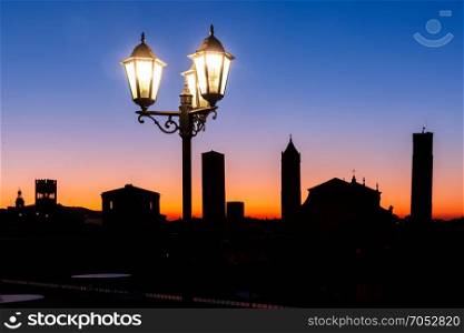 Aerial view of towers and roofs in Bologna, Italy. Night aerial view of Bologna Cathedral and towers of Old Town in medieval city Bologna with vintage beautiful lantern at sunset, Emilia-Romagna, Italy
