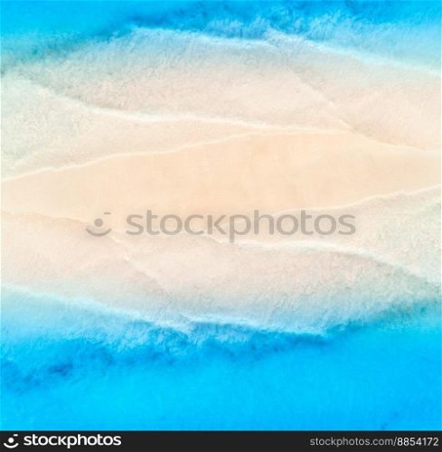 Aerial view of transparent blue sea with waves on the both sides  and empty sandy beach at sunset. Top view of sandbank. Summer travel in Zanzibar, Africa. Tropical landscape with white sand and ocean
