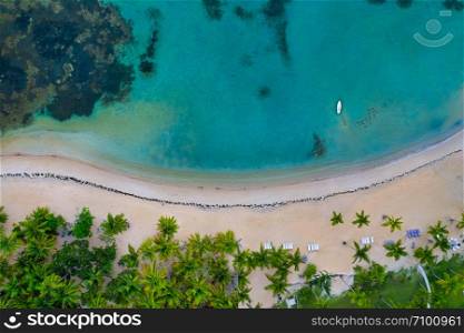 Aerial view of tropical beach with white boat anchored.Samana peninsula,El Portillo beach,Dominican Republic.