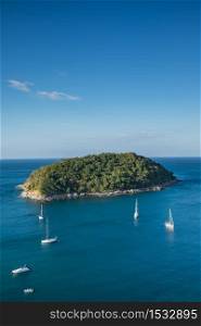 Aerial view of tropical island on sea with sailboat near promthep cape phuket,thailand
