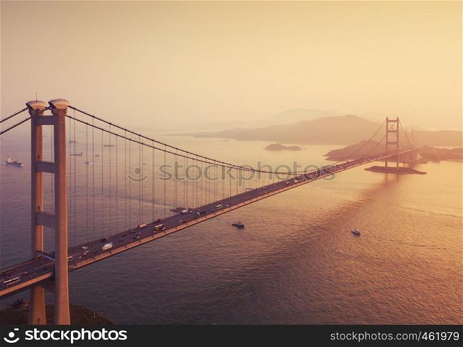 Aerial view of Tsing Ma Bridge. Highways in Hong Kong with structure of suspension architecture in transportation and travel concept. Urban city at sunset.