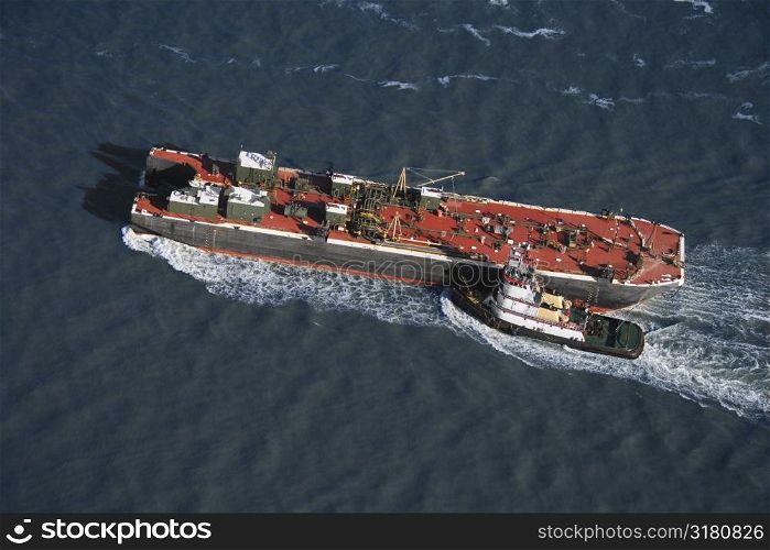 Aerial view of tugboat pushing tanker.