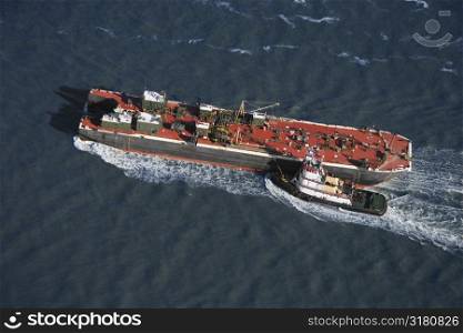 Aerial view of tugboat pushing tanker.