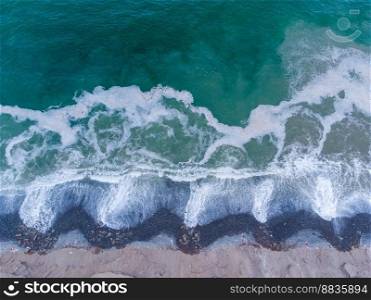 Aerial view of turquoise waves reaching the shore