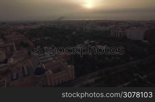 Aerial view of Valencia with houses and green park at sunset, Spain