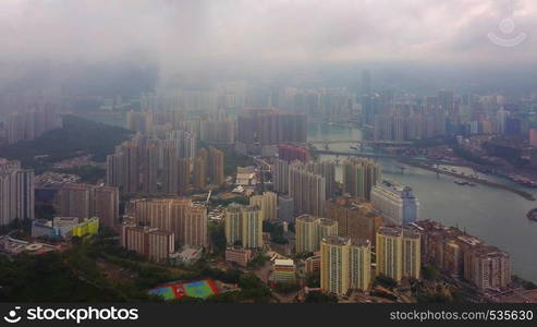 Aerial view of Victoria Harbour, Hong Kong Downtown with rain storm, Republic of China. Financial district and business centers in smart city in Asia. Skyscraper and high-rise buildings at sunset