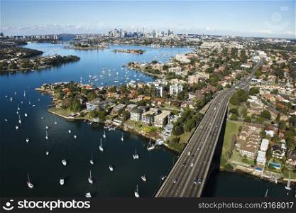Aerial view of Victoria Road bridge and boats with distant downtown skyline in Sydney, Australia.