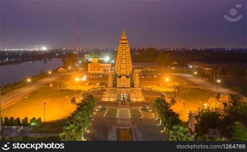 Aerial view of Wat Panyanantaram at night, a Buddhist temple in Pathum Thani City, Thailand. Thai architecture buildings background in travel trip concept. Buddhism religion. Tourist attraction.