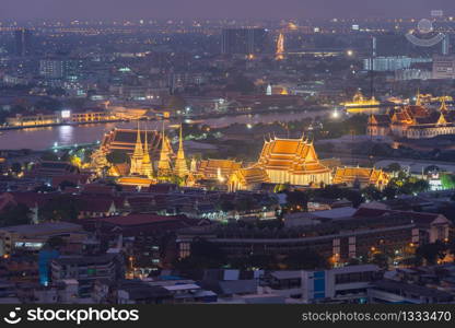 Aerial view of Wat Pho or Wat Phra Chetuphon Vimolmangklararm Rajwaramahaviharn with residential buildings at night in Bangkok City, Thailand. Buddhist temple. Thai architecture.