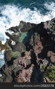 Aerial view of waves crashing on rocks in Maui, Hawaii.