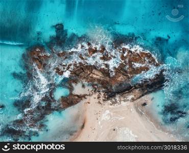 Aerial view of waves, rocks and transparent sea. Summer seascape with ocean, sandy beach, beautiful waves, cliffs, blue water at sunset. Top view from drone. Rocky coastline. Travel. Maldives. Concept