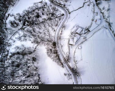 Aerial view of winding road through snowy landscape in Asturias mountains in Spain. Winter time.