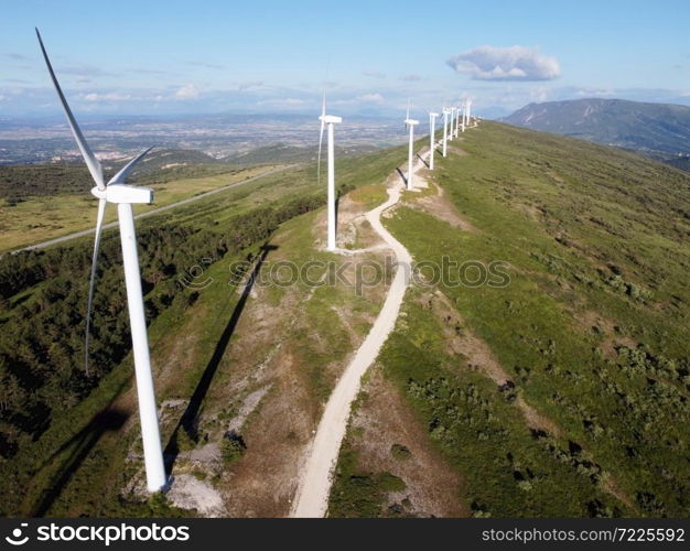 Aerial view of windmills farm for renewable energy production on beautiful blue sky. Wind power turbines generating clean renewable energy for sustainable development. High quality 4k footage.. Aerial view of windmills farm for renewable energy production on beautiful blue sky. Wind power turbines generating clean renewable energy for sustainable development