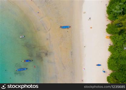 Aerial view or top view of long-tailed boat is floating on the emerald sea. Calm andaman sea at Phuket, Thailand. Kata beach