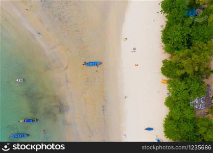 Aerial view or top view of long-tailed boat is floating on the emerald sea. Calm andaman sea at Phuket, Thailand. Kata beach