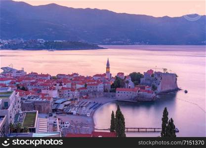 Aerial view over Old Town of Montenegrin town Budva on the Adriatic Sea at pink sunrise, Montenegro. Old Town of Budva, Montenegro