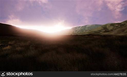 Aerial View. Sunset. Flight over a green grassy rocky hills. Aerial Green Hills Landscape in Fog